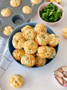 some muffins are in a blue bowl next to other food items