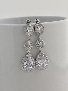 Absolutely brillant! I've created these super sparkly clear cubic zirconia bridal dangle teardrop halo earrings in rhodium plated brass setting. Earrings feature a teardrop with pear cut clear cubic zirconia center surrounded by tiny round zirconia crystals. Teardrop dangles from clear cubic zirconia teardrop ear stud and a beautiful halo cubic zirconia connector. Total length of the earrings is 4 cms. For matching necklace click: https://www.etsy.com/listing/495452358/bridal-cubic-zirconia-neck Dazzling Cubic Zirconia Dangle Bridal Earrings, Bridal Drop Earrings With Cubic Zirconia Stones, Bridal Drop Earrings With Sparkling Cubic Zirconia, Silver Chandelier Earrings With Diamond Accents, Silver Pear-shaped Chandelier Earrings With Diamond Accents, Drop Chandelier Earrings With Sparkling Stones, Anniversary Dangle Bridal Earrings In Cubic Zirconia, White Gold Teardrop Cubic Zirconia Chandelier Earrings, Pear-shaped Diamond White Cubic Zirconia Bridal Earrings