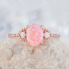 A classical vintage oval opal ring in 10K 14k or 18k gold, pictured in rose gold. Unique oval cut pink fire opal engagement ring, wedding ring, anniversary ring gift for girl, women, best friend, wife and her. The opal is a representative of justice and harmony, and is a protective stone in dangerous places.  ITEM DESCRIPTION ★Center Stone: 0.8 Carat 8x6mm Oval Cut Lab Pink Fire Opal ★Side Stone: 2mm round cut lab created white opal  ★Accent Stone:0.18CT Diamonds or Moissanite   Accent Stone: Cubic Zircon with Silver Ring ★Shank Width(Bottom):1.5mm *Purchase Guarantee: 1: Provide you with the best service. 2: 30 Days Refund Guarantee. 3: Free Gift Box and Packing. *Processing time: When we receive payment We need 2-3 weeks to work for your items in perfect by hand. Please contact us if you Pink Fire, Cute Engagement Rings, Opal Wedding, Future Engagement Rings, Opal Wedding Rings, Promise Ring Gift, Opal Engagement, Engagement Rings Opal, Dream Engagement Rings