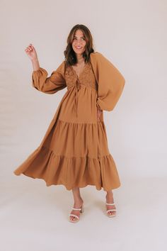 Get ready to fall head over heels for our Falling Faster Dress! This caramel-colored dress features delicate lace detailing and a charming tied bow on the front of the bodice. The smocked panel in the back ensures a comfortable and flattering fit, while the tiered skirt adds a whimsical touch. Complete with long, slightly puffed sleeves and a midi length, this dress also boasts a lace-trimmed neckline for an extra feminine touch. You'll be turning heads and feeling fabulous in this stunning dres Brown Dress With Smocked Back For Daywear, Brown Dress With Smocked Bodice For Daywear, Brown Smocked Bodice Dress For Daywear, Lace Dress With Smocked Bodice For Brunch, Brown Tie Back Dress For Spring, Brown Tie-back Dress For Spring, Spring Brown Dress With Tie Back, Brown Smocked Bodice Midi Dress For Brunch, Brown Midi Dress With Smocked Bodice For Brunch