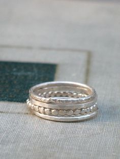 A lovely set of rustic sterling silver stacking rings to mix and match.  Each band is made from a different shape stock and has a hammered texture, there is one square band, one dotted, one hammered, and one with a unique dashed texture.  Sets are available in a bright or oxidized finish and are made to order in whole and half sizes 4 through 11.Add a silver eternity necklace and make it a set- https://www.etsy.com/listing/50117625Stacking rings are also available in a gold filled- https://www.e Sterling Silver Wedding Rings Sets, Modern Rings, White Gold Diamond Wedding Rings, Simple Silver Jewelry, Silver Rings Simple, Silver Rings With Stones, Sterling Silver Stacking Rings, Zierlicher Ring, Stacking Ring Set