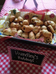 a basket full of hotdogs sitting on top of a red and white checkered table cloth