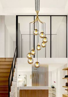 an elegant chandelier hangs from the ceiling in this entryway with wooden steps