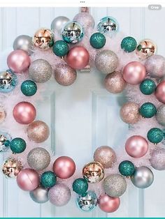 a christmas wreath with pink, green and gold ornaments