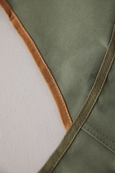 a close up view of the side of a green and tan jacket with an orange stripe