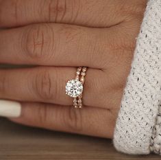 a woman's hand with two rings on her fingers and one ring in the middle