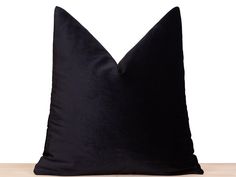 a black pillow sitting on top of a wooden table