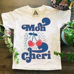 "Mon Cheri - (KIDS TEE): Designed and handmade in Phoenix. This adorable, retro-inspired French design, with two delectable cherries to top it all of, makes the perfect gift. This listing is for: (ONE) \"Mon Cheri\" KIDS TEE ★CURRENT PROMOTIONS! ★ >Keep an eye out for our 20% off flash sale! We run it randomly, so be sure to keep checking back! >When sale is running, add items to your cart and the discount will automatically show at checkout >Free shipping over $35! Current Turnaround i Playful T-shirt With Funny Print As Gift, Playful White T-shirt With Funny Text, Playful Cotton T-shirt With Letter Print, Retro Funny Print T-shirt As Gift, Cute Text Print T-shirt As Gift, Playful Graphic Print Tops As Gift, Playful White T-shirt With Slogan, Playful White Slogan T-shirt, Playful Summer T-shirt Gift