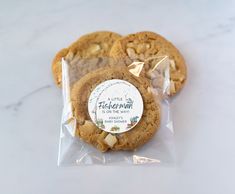 two cookies in a plastic bag with a thank you sticker on the top one