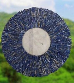 a blue and white circular object in the middle of a field with mountains in the background