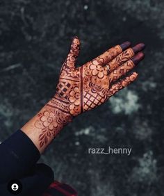 a woman's hand with henna tattoos on it