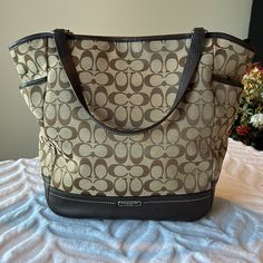 Excellent Condition! Tan Fabric With Dark Brown Leather Trim. Two Side Storage Pockets And One Large Pocket On Back Of Purse With Magnetic Snap Closure. Inside Has One Large Zippered Pouch, One Small Slip Pocket And One Larger Slip Pocket. Top Closes With A Zipper. Storage Bag Included. Smoke And Pet Free Home. Zipper Storage, Tan Fabric, Zippered Pouch, Pocket Top, Coach Purse, Dark Brown Leather, Coach Purses, Leather Trim, Tan Brown