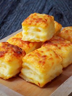 four cheesy biscuits on a cutting board ready to be eaten with cheese and sauce