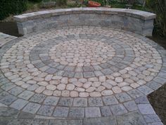 a circular stone bench in the middle of a garden