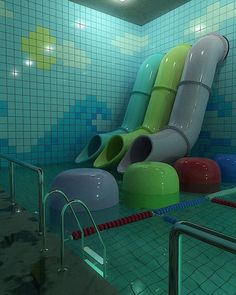 an indoor swimming pool with water slides and colorful tiles