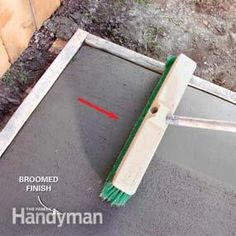 a broom is laying on the ground next to a hole with a red arrow pointing towards it