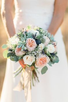 a bridal holding a bouquet of flowers and greenery