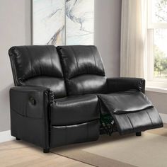 a black leather reclining loveseat in a living room