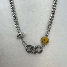 Unleash your inner streetwear punk with our Planet Smiley Face Necklace! This versatile and stylish piece is perfect for both men and women, exuding a cool and edgy vibe. Make a statement and express your unique style with this unisex accessory. Necklace length 16.0 inch with 1.8 inch extension chain, Chain width 7 mm. Smiley Face Necklace, Punk Streetwear, Adopt Idea, Face Necklace, Women Streetwear, Hip Hop Style, Unisex Accessories, Necklace For Men, Streetwear Women