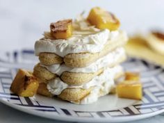 a stack of desserts sitting on top of a blue and white plate next to bananas