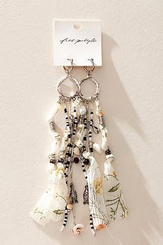 a keychain hanging from the side of a wall with beads and tassels