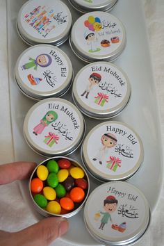 several tins filled with candy sitting on top of a white tray next to each other