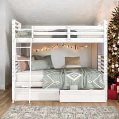 a white bunk bed sitting next to a christmas tree