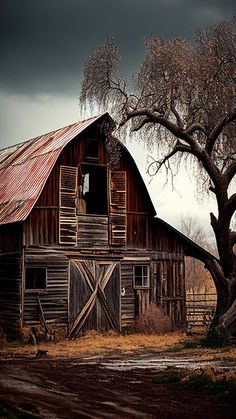 an old barn with a tree in the foreground