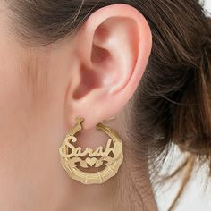 An alluring look with personalized details, these hoop earrings draw all the right kinds of attention. Created in 14K gold over silver, each tapered hoop features a unique bamboo-textured design. Across the center, the name of your choice - from three to 10 characters in length - is sculpted in a script font and set atop a heart. Filigree ribbons and a pair of heart-shaped leaf details complete the style. Polished to a bright shine, these hoop earrings secure with latch backs. Anniversary Gold Huggie Earrings Pierced, Elegant Personalized Hoop Earrings, Personalized 14k Gold Earrings For Anniversary, Small Hoop Engraved Jewelry For Anniversary, Elegant Personalized Hoop Jewelry, Elegant Personalized Hoop Earrings For Anniversary, Personalized Elegant Hoop Jewelry, Small Engraved Hoop Earrings, Personalized 14k Yellow Gold Earrings