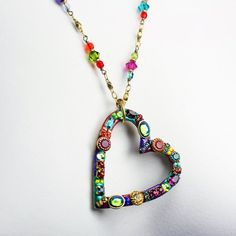 This heart hoop necklace embellished with a wide variety of multi-color Swarovski crystal and glass beads set into rainbow enamel placed on a chain beaded with Swarovski crystals and glass beads is inspired by it's own abstract and bright shape. This handmade piece is a one of a kind, fashionable statement necklace that will be perfect for any spring outfit or as a lovely gift for valentine's day.Pendant Length: 1.75 inchesPendant Width: 1.5 inchesNecklace Length: 20.25 inchesAdditional Extender Bohemian Crystal Jewelry With Colorful Beads, Valentine's Day Beaded Metal Jewelry, Colorful Beads Metal Jewelry For Gift, Colorful Beads Metal Jewelry Gift, Colorful Beaded Metal Jewelry As A Gift, Colorful Beaded Metal Jewelry For Gifts, Bohemian Multicolor Enamel Necklaces, Bohemian Multicolor Crystal Beaded Necklaces, Bohemian Multicolor Enamel Necklace