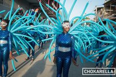 two women in blue and silver costumes walking down the street