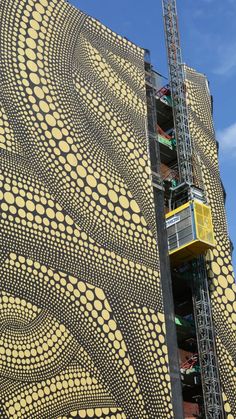 the building is covered in yellow circles and scaffolding