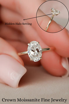 a close up of a person's hand holding a ring with a diamond on it