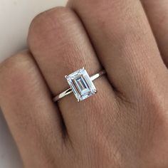 a woman's hand with a ring on it and a diamond in the middle