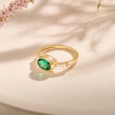 Elevate your promise with our Gold Oval Emerald Framed Promise Ring. A delicate oval emerald set in a delicate frame symbolizes enduring love. Crafted from polished 14-karat gold, this ring combines sophistication and sensuality, a timeless expression of devotion. - Made in 14k solid gold - Decorated with lab-created emerald - Band Width: 1.59 mm / 0.06 inches - Top Width: 10.0x8.0 mm / 0.39x0.31 inches - Thickness: 1.44 mm / 0.05 inches - This product comes with an iconic Norm Jewels gift box Elegant Emerald Ring With Oval Cabochon, Fine Jewelry Emerald Oval Cabochon Ring For May Birthstone, Elegant 14k Gold Emerald Ring With Halo Design, Elegant Emerald Ring For May Birthstone And Formal Events, Elegant Oval Emerald Ring In Yellow Gold, Elegant Oval Green Diamond Ring, Elegant Oval Emerald Ring For Formal Occasions, Elegant Yellow Gold Oval Emerald Ring, Elegant Oval Emerald Ring With Halo Setting