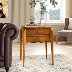 a living room scene with focus on the end table and chair, which has an olive tree in it