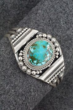 This beautiful natural Kingman turquoise and sterling silver bracelet was made by Navajo silversmith Tom Lewis. The back is signed Tom Lewis and sterling.Size: 5 1/2" (will fit up to a 6 5/8" wrist)Gap: 1 1/8"Width: 1 5/8"Cuff Width: 1/2"Free shipping on all orders! We ship with USPS and always include tracking. All orders ship within a day of payment.Returns are accepted up to 30 days after you receive your order. Just send us a message. Our shop offers cash back or store credit. The item must be returned in new condition. Artisan Turquoise Sterling Silver Bracelet, Western Turquoise Bracelet With Patina, Western Turquoise Bracelet With Concho, Western Turquoise Bracelets With Concho, Western Style Turquoise Bracelet With Concho, Bohemian Engraved Turquoise Sterling Silver Bracelet, Bohemian Turquoise Engraved Sterling Silver Bracelet, Southwestern Silver Jewelry With Patina, Artisan Sterling Silver Turquoise Bracelet Collectible