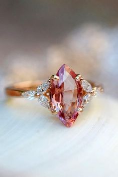 an oval shaped pink sapphire and diamond ring