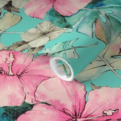 pink and blue flowers on a turquoise wallpaper with a white cup in the foreground