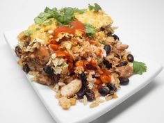 a white plate topped with rice, beans and other foods on top of each other