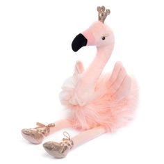 a pink flamingo doll sitting on the ground with its legs spread out and shoes in front of it