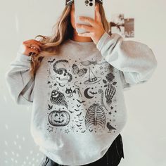 This Halloween Shirt has a retro vibe with fun spooky season graphics. You will want to wear this cute Fall shirt on repeat.  This is a relaxed fit unisex sweatshirt, but true to size. We recommend sizing up if you want a trendy oversized look. - M A T E R I A L S - Gildan® Sweatshirt 8 oz./yd² (US) 50/50 cotton/polyester Heather Sport colors: 60/40 polyester/cotton Loose Fit Ribbed Knit Collar to retain shape - C A R E  I N S T R U C T I O N S - Inside out, wash with delicate cycle Do not iron Spooky Skull Print Top For Fall, Spooky Skull Print Fall Top, Spooky Skull Print Tops For Fall, Spooky Long Sleeve Graphic Print Tops, Spooky Long Sleeve Tops With Graphic Print, Halloween Cotton Sweatshirt With Skull Print, Cute Halloween Streetwear Tops, Cute Tops For Halloween Streetwear, Halloween Long Sleeve Screen Print Tops