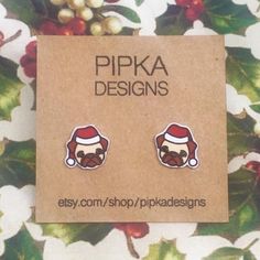 Festive Christmas Pug stud earrings.These earrings are made from shrink plastic with surgical stainless steel posts. They are approximately 12mm wide. Each pair of earrings is handcrafted.SHIPPINGI ship with Australia Post. Shipping times can vary depending on factors that are out of my control. If you wish for your parcel to be tracked then please upgrade to tracked/express postage. - Within Australia -Regular Post $2 Approximately 2-6 business daysDoes not include trackingTracked Post $7.95App Pug Earrings, Christmas Pug, Christmas Clay, Plastic Earrings, 50 Christmas, Shrink Plastic, Wishes For You, Festive Christmas, Jewelry Earrings Studs