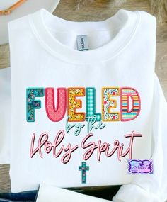 Fueled By The Holy Spirit Shirt, faux embroidery -Available in Adult & Youth Sizes -Choose shirt color and shirt type when ordering, see color/size charts for choices. -Colors may vary slightly due to lighting and monitor settings -No decorative accessories pictured are included, only the shirt! White Long Sleeve Shirt With Embroidered Graphics, White Long Sleeve Shirt With Machine Embroidery, Embroidered Crew Neck Shirt For Fall, Fall Embroidered Crew Neck Shirt, Long Sleeve T-shirt With Multicolor Embroidery, Long Sleeve Tops With Multicolor Embroidery And Letter Print, Multicolor Embroidered Long Sleeve Top With Letter Print, Multicolor Embroidery Long Sleeve Top With Letter Print, White Shirt With Embroidered Text For Spring