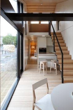 an open floor plan with stairs leading up to the kitchen and dining room area in this modern home