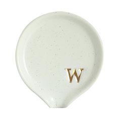 a white plate with the letter w on it's side and two gold letters at the bottom