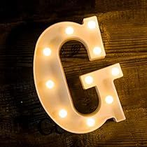 the light up letter g is displayed on a wooden surface with lights around it and underneath it