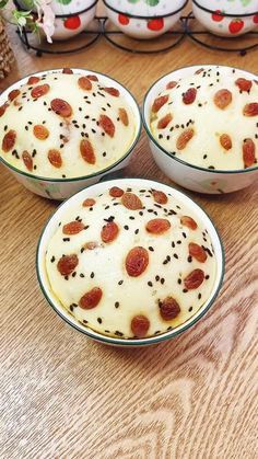 three bowls filled with food sitting on top of a wooden table next to other dishes