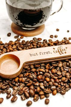 a wooden spoon sitting on top of coffee beans