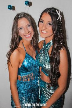 two women dressed in blue and silver posing for the camera